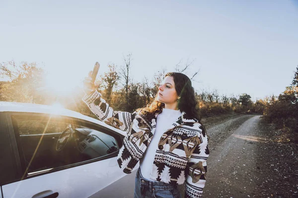 Vrouw Kijkt Naar Mobiele Naast Een Auto Een Weg Tussen — Stockfoto