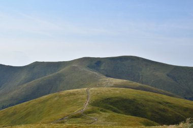 Dağları ve mavi gökyüzü olan güzel bir manzara.