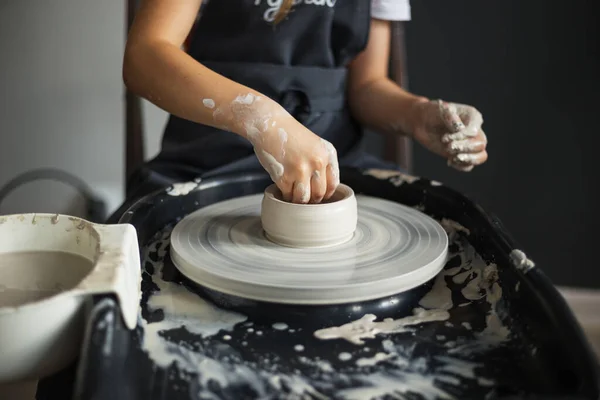 陶工の車輪の上にボウルを作成する少女の手 伝統工芸だ 陶芸教室で陶芸家の車輪の上の粘土のモデリングに関するマスタークラス ボウルに集中する — ストック写真