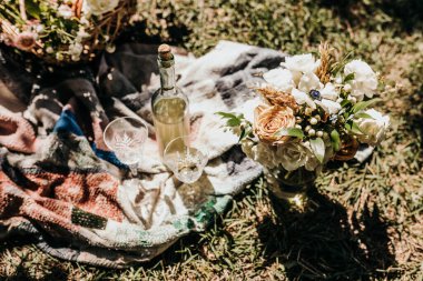 Picnic with wine and a fresh bouquet of flowers on a sunny day