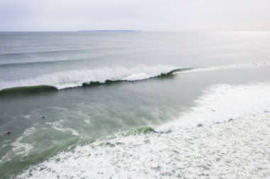 Aerial of Surfers on long hurricane waves in Rhode Island