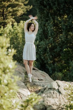 Teen ballerina dancing outside on rocks