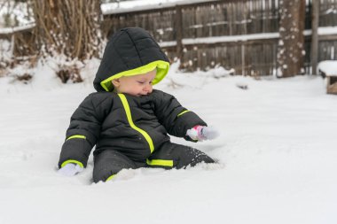 Karda oynayan küçük bir kız çocuk.