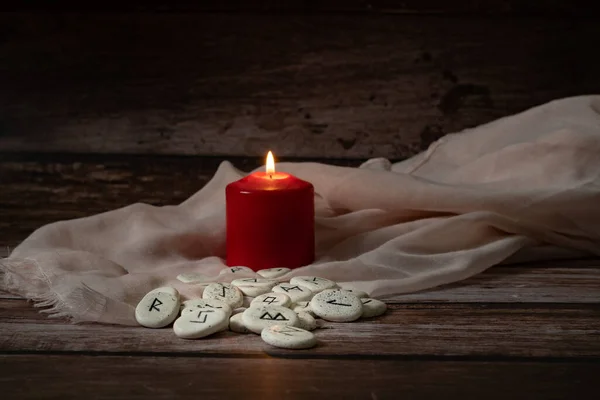 木制桌子上挂着蜡烛 用黑色符号表示好运的沙丘石 — 图库照片