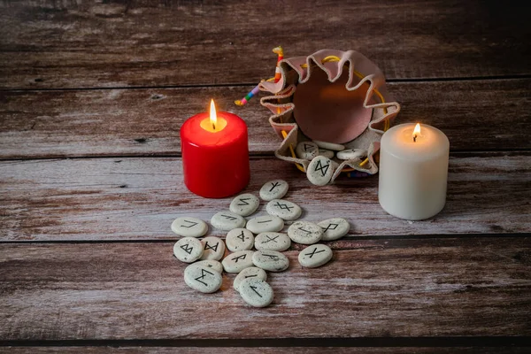 木制桌子上挂着蜡烛 用黑色符号表示好运的沙丘石 — 图库照片