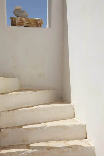 White Staircase Leading up by a Window with Rock Arrangement and