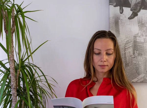 Blonde Woman Red Shirt Reading Magazine Green Plant — Stock Photo, Image