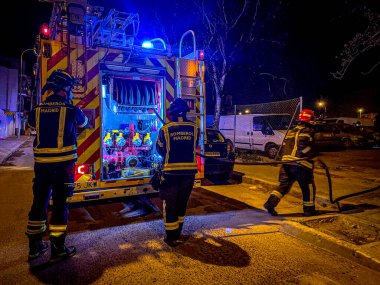 İtfaiyeciler ve itfaiye aracı itfaiye üzerinde çalışıyor.