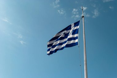 Mavi gökyüzünde dalgalanan Yunan bayrağı