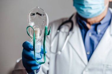 Doktor bir hastaya solunum cihazı veriyor.