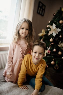 Erkek ve kız kardeş kameraya bakıyorlar..