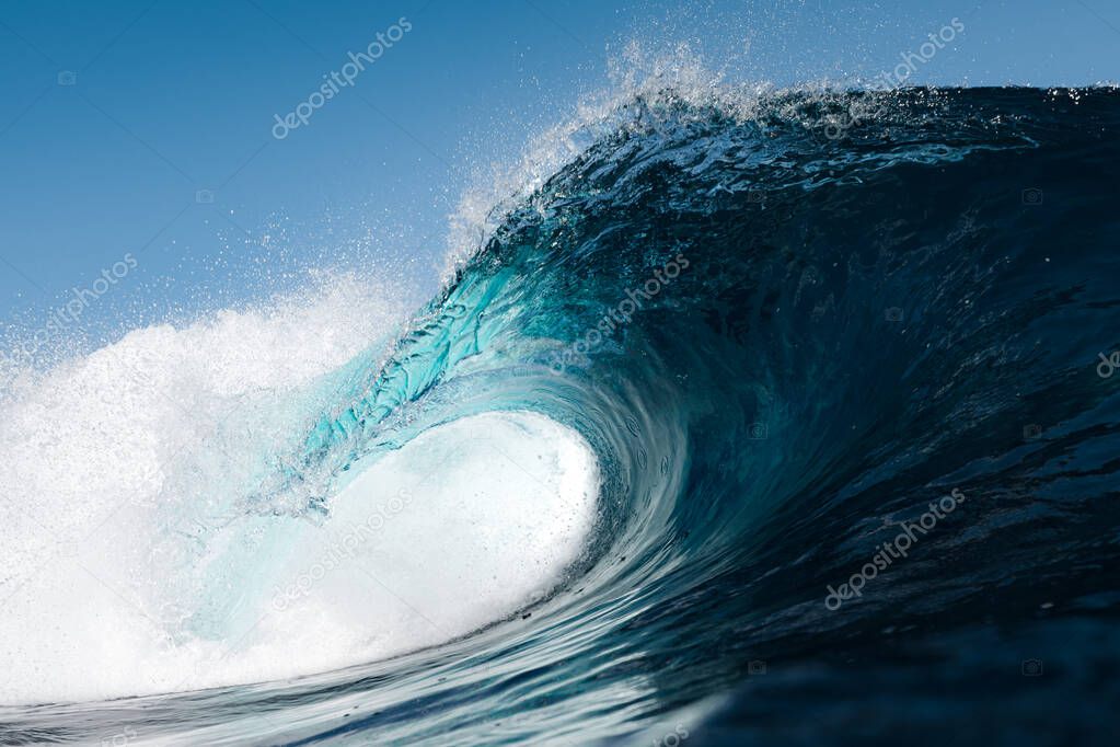 Blue wave splashing on a beach in summer