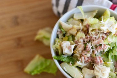 Beyaz kasede tavuk ve domuz pastırması olan bir salata yakın plan..