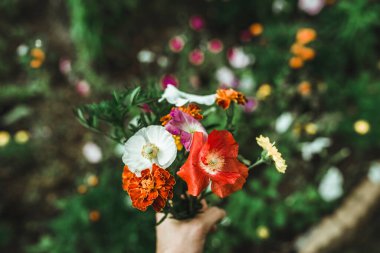 El ele tutuşmuş taze çiçekler.