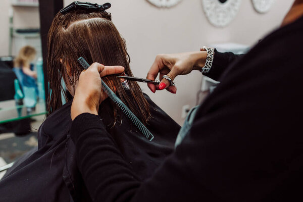 Little girl getting haircut by woman