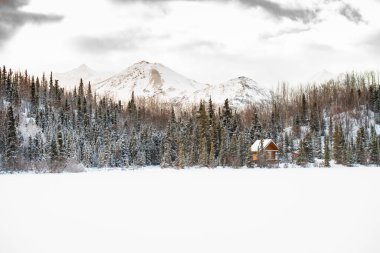 Alaska 'da donmuş bir gölün kenarında küçük bir kulübe.