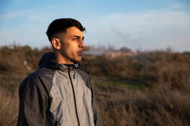 Açık havada esrar içen bir gencin yakın çekimi.