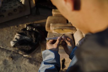 Açık havada esrar saran bir çocuğun ellerinin yakın çekimi.