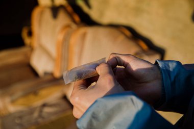 Açık havada esrar saran bir çocuğun ellerinin yakın çekimi.