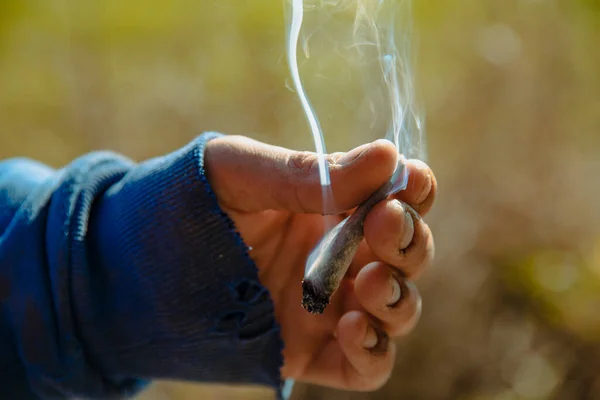 一个拿着大麻香烟的小男孩的手部特写 — 图库照片