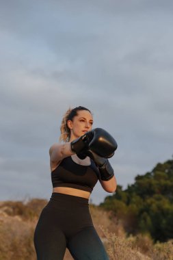 Açık havada boks eldivenli genç bir kız