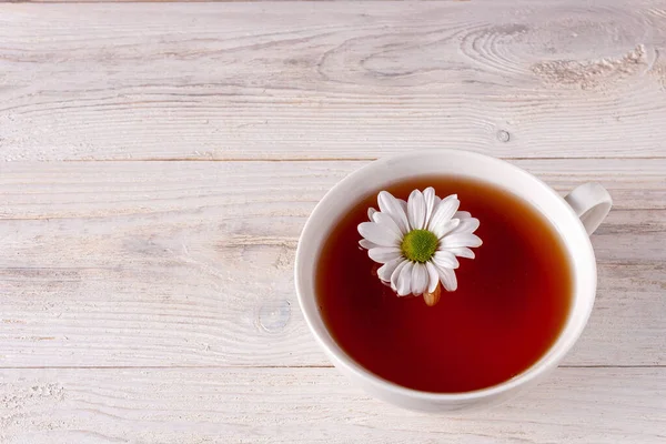 Weiße Chrysanthemenblume Schwimmt Einer Tasse Tee Auf Weißem Holzgrund Mit — Stockfoto