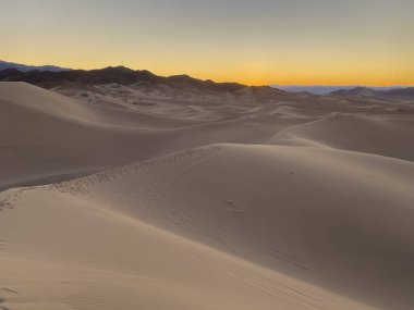 Gün batımında kum tepesinde ışık ve doku.