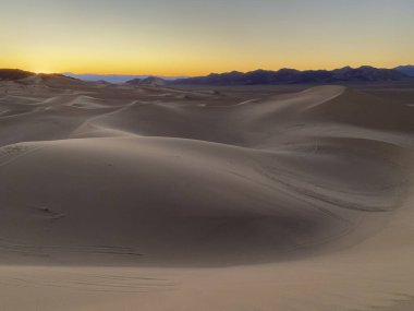Gün batımında kum tepesinde ışık ve doku.