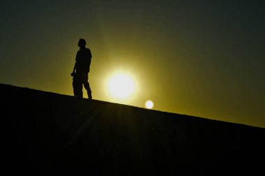 Gün batımında yürüyen adam silüeti