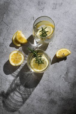 Limonlu ve aromalı bitkilerle dolu bardaklar.