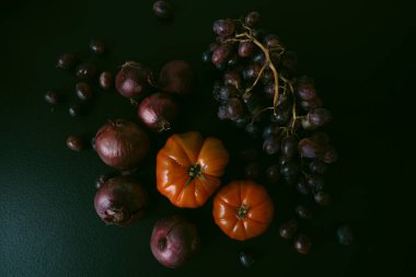 Soğan, domates, üzüm, siyah arka plan.