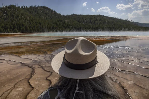 A US Park Ranger looks out over Grand Prismatic Spring.