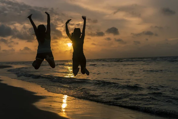 Силуэт Двух Молодых Девушек Прыгающих Веселящихся Пляже — стоковое фото