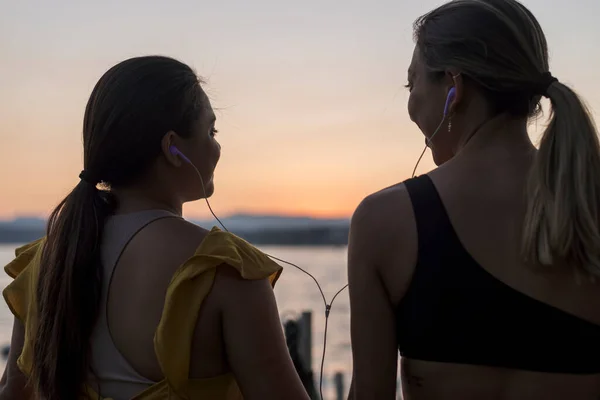 Zwei Lächelnde Mädchen Teilen Sich Ohrenstöpsel Hören Musik Und Lächeln — Stockfoto