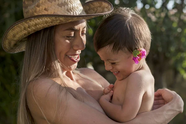 若いラテン語のお母さん抱擁彼女の息子と笑顔で晴れた日の午後 — ストック写真