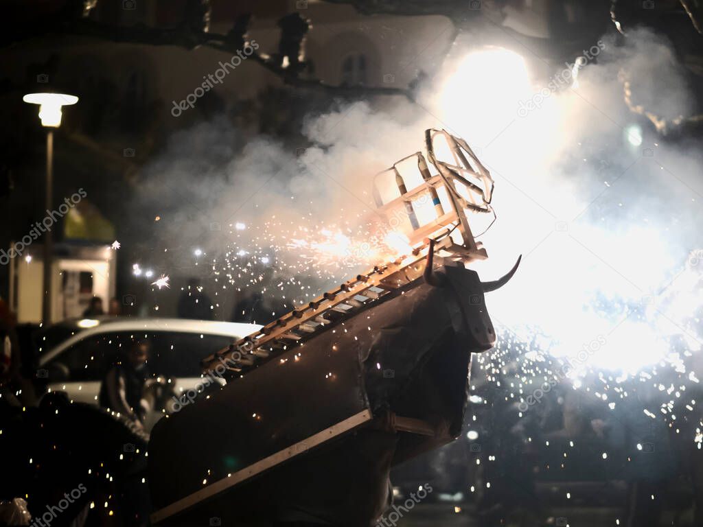 fire bull at night in traditional regional festivals, carnivals. firecrackers and rockets