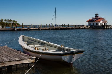 Arka planda bina olan iskelede tekne var.