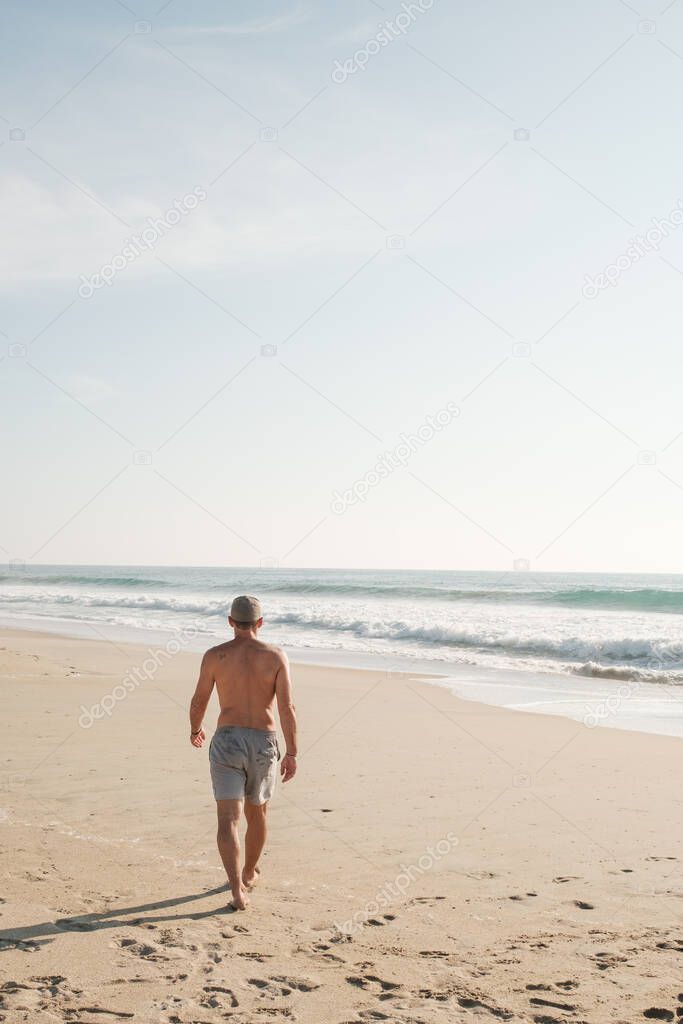 Man walking on the beach at sunset in Mexico