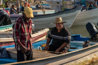 Zavallı Latin balıkçılar gün doğumunda çalışmak için teknelerine hazırlanıyorlar.