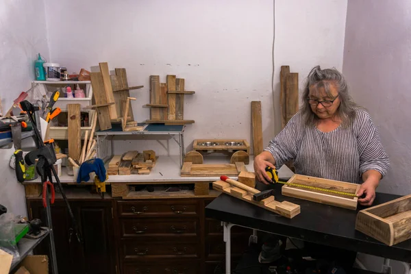 白髪の女性がリサイクル木材工場で働いています — ストック写真