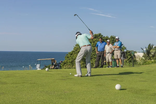 Group of latin golfers playing on a course near the sea