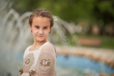 Bir parkta fıskiyenin önünde poz veren komünist kız.