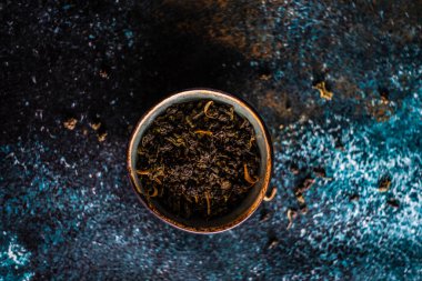 Beton zemin üzerinde mango parçaları olan yeşil sencha çay yaprakları.