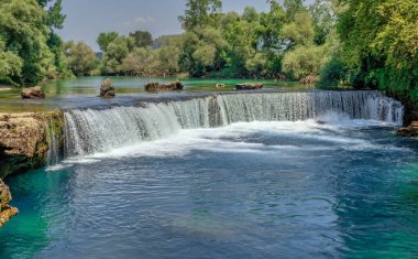 Güneşli bir yaz gününde Türkiye 'nin Antalya ilinde Manavgat şelalesi ve nehri
