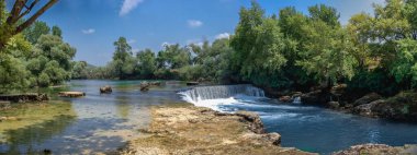 Güneşli bir yaz gününde Türkiye 'nin Antalya ilinde Manavgat şelalesi ve nehri