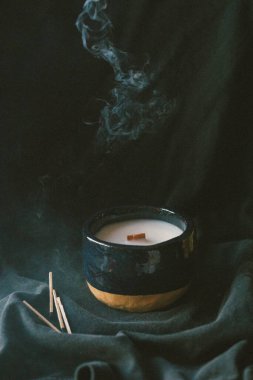 Duman ahşap fitili mumun üzerinde, kibritle birlikte.