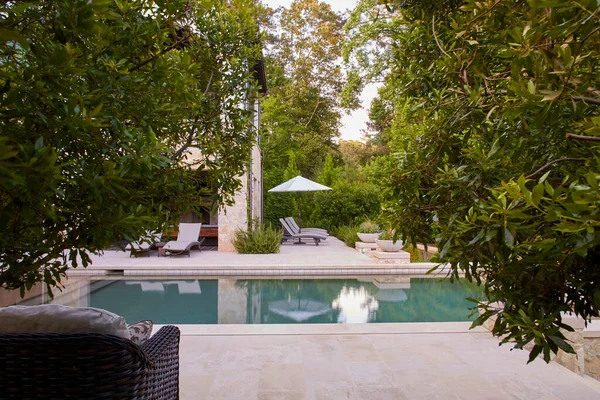 Pool through bushes Mediterranean style house