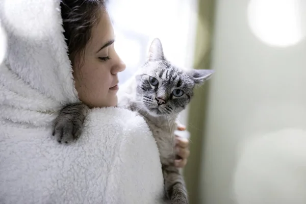 少女抱着一只蓝眼睛的灰色禁忌猫 回头看她的肩膀 — 图库照片