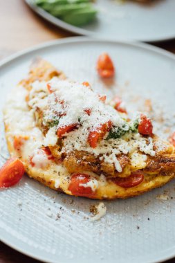 Ev yapımı kahvaltı tabağı: peynirli omlet ve domates..