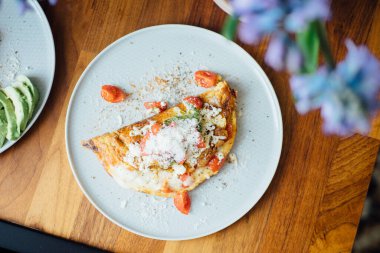 Ev yapımı kahvaltı tabağı: peynirli omlet ve domates..